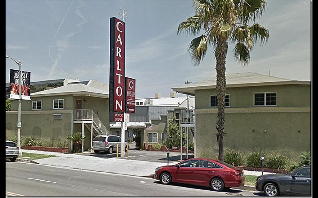a red car parked in front of a hotel at Carlton Motor Lodge in Los Angeles