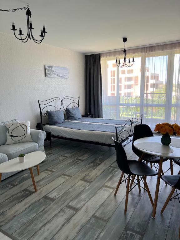 a bedroom with a bed and a couch and tables at Studio E32 Atia Resort Chernomoretz in Chernomorets