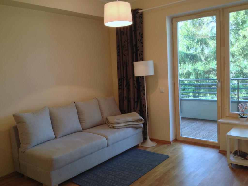 a living room with a couch and a sliding glass door at Fortuuna 5 Apartment in Tartu