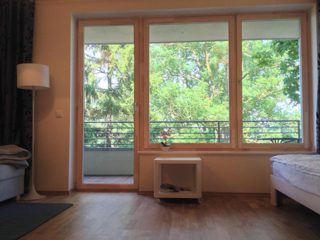 a bedroom with a large window with a bed and a balcony at Fortuuna 5 Apartment in Tartu