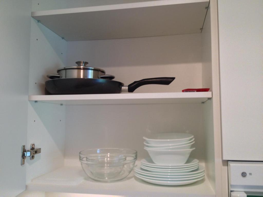 a pantry with dishes and a pot on a shelf at Fortuuna 5 Apartment in Tartu