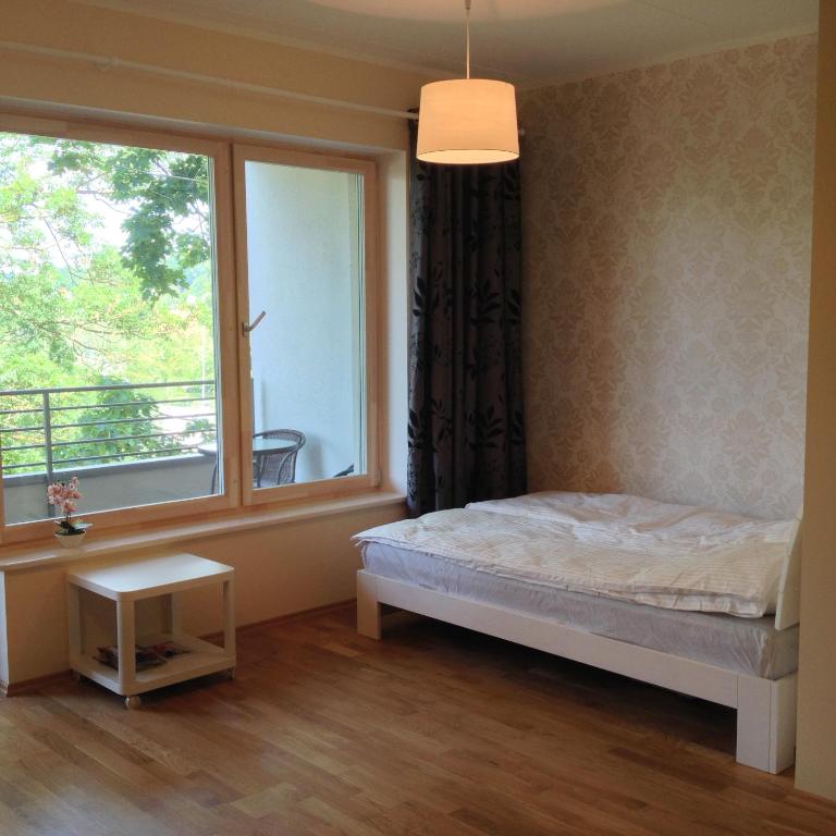 a bedroom with a bed and a large window at Fortuuna 5 Apartment in Tartu