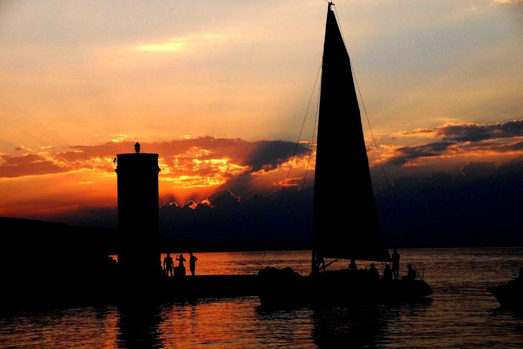 a sail boat on the water at sunset at Apartment Lana in Senj