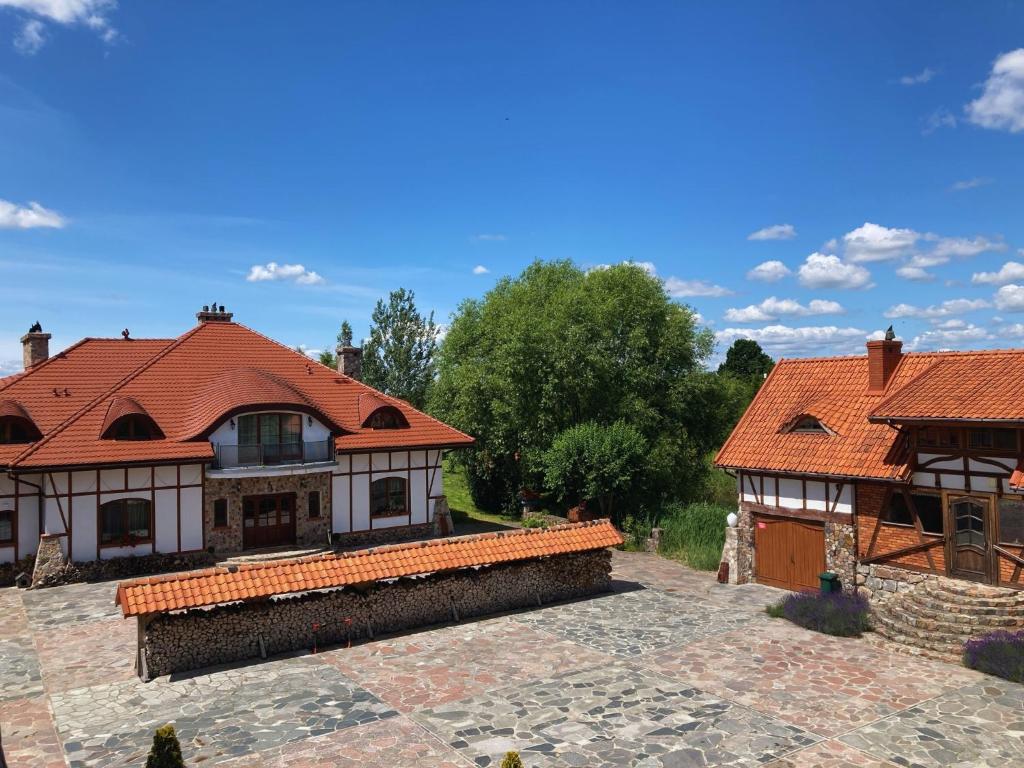 a house with red roofs and a courtyard at Rezydencja Gołębiówka Mazury in Targowo