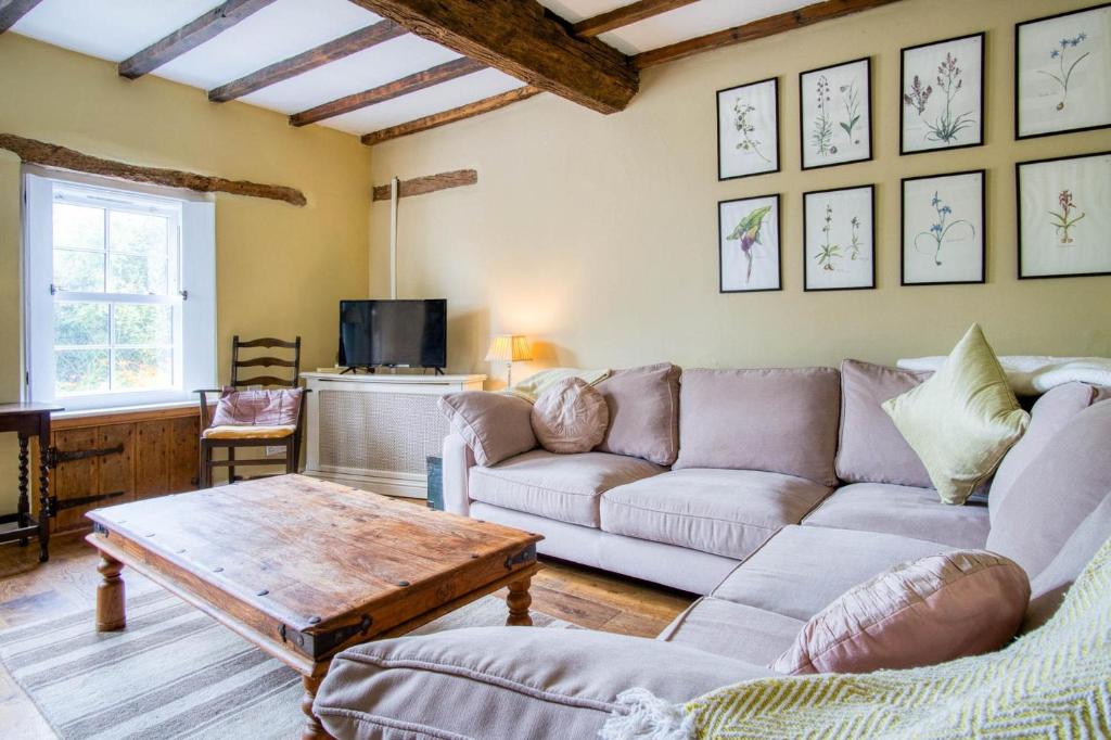 a living room with a couch and a coffee table at Bwthyn Berwig - 3 Bedroom Cottage - Llanrhidian in Swansea
