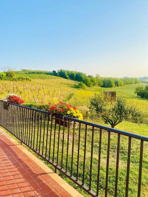 a fence with flowers on it next to a field at Corte del Vigneto in Montemagno