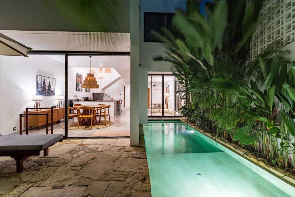 une piscine dans une maison avec une salle à manger et une cuisine dans l'établissement Villa Castello Canggu, à Canggu