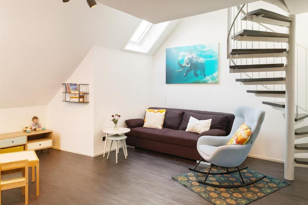 Ferienwohnung Maisonette am See في Markelfingen: غرفة معيشة مع أريكة ودرج