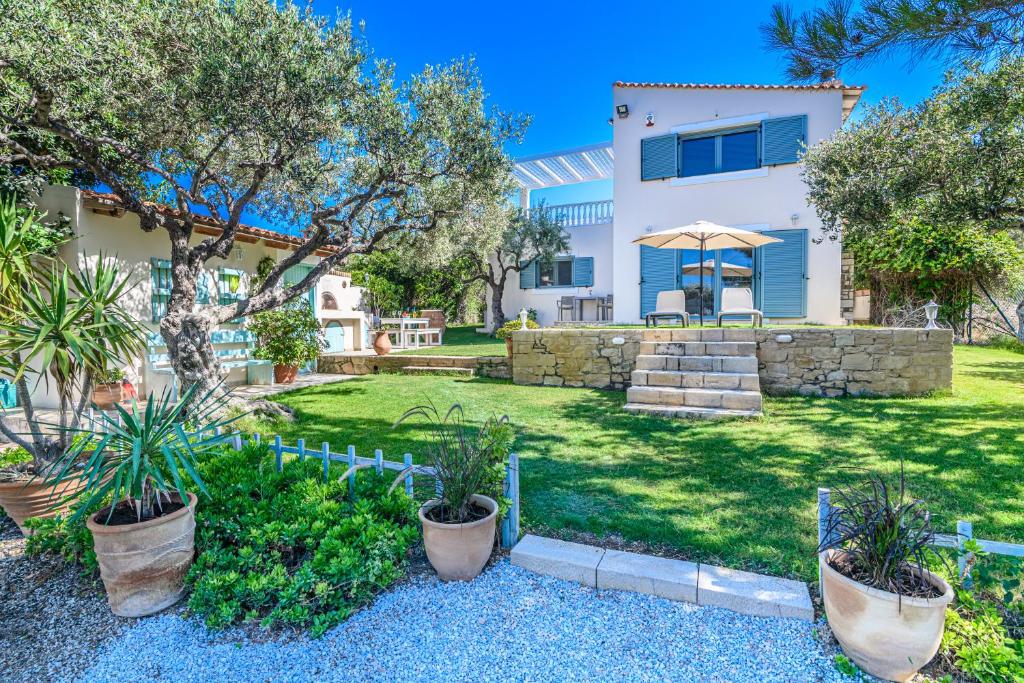una casa con un patio con árboles y plantas en Delightful Seaside Villa, en Gouves