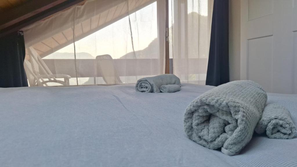 a bed with two stuffed animals on top of it at Charming apartment with great view in Ovronnaz