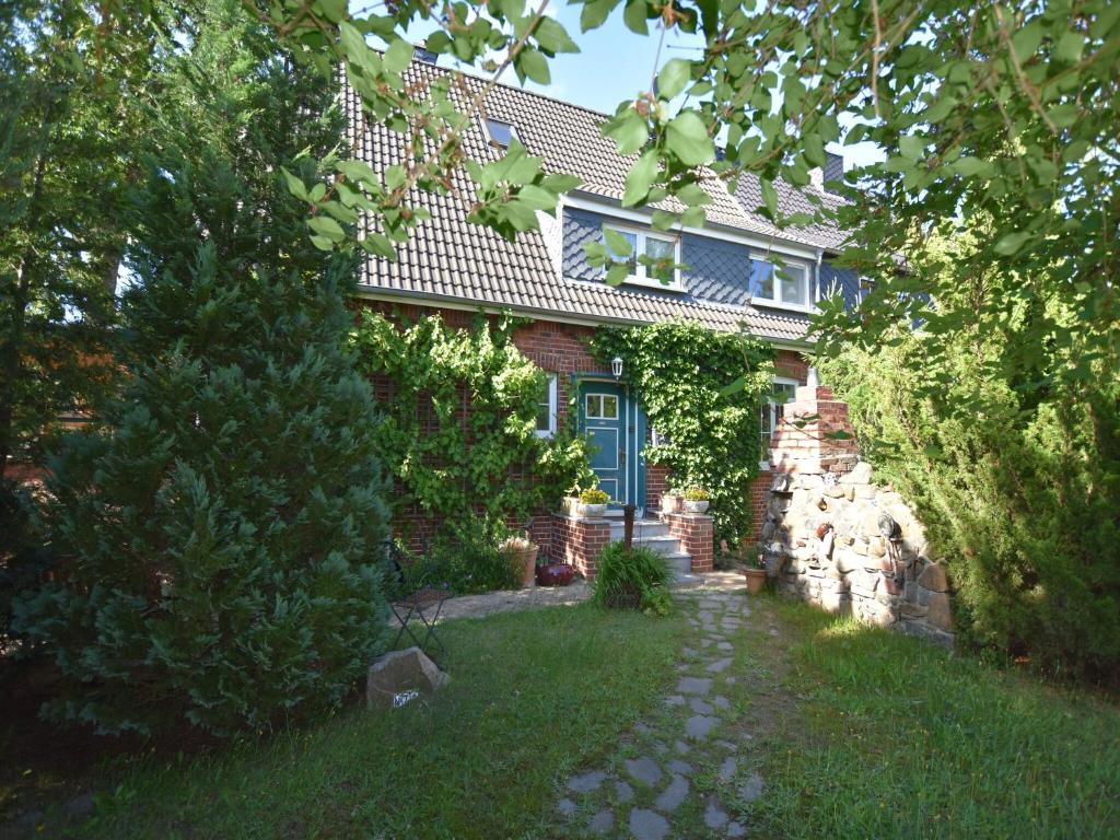 a brick house with a blue door and a yard at Peaceful Apartment in Ostseebad Boltenhagen with Terrace in Boltenhagen