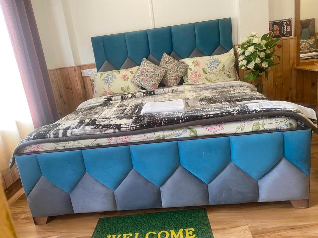 uma cama com uma cabeceira azul num quarto em Om parvati em Kasol