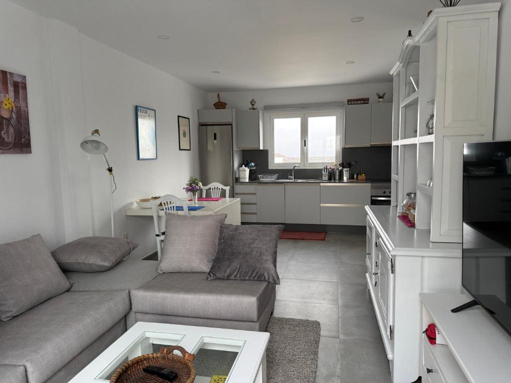 a living room with a couch and a kitchen at Finca Seño Donato Lomo La Santa in Tinajo