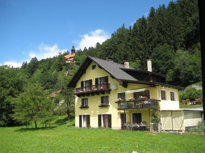 una casa amarilla con balcones en un campo verde en Gästehaus Santer, en Rothenthurn