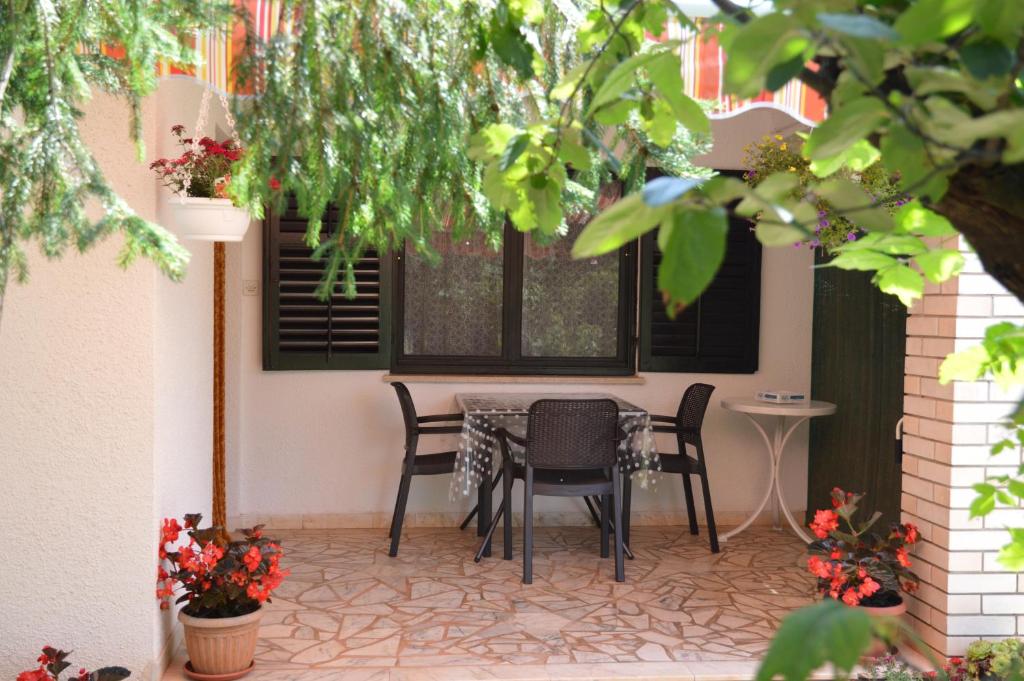 d'une terrasse avec une table, des chaises et une fenêtre. dans l'établissement Holiday Home Leni, à Fažana
