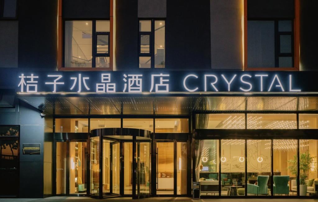 budynek z szyldem na froncie w obiekcie Orange Crystal Hotel Shenzhen Baoan Airport Bihaiwan w mieście Bao'an