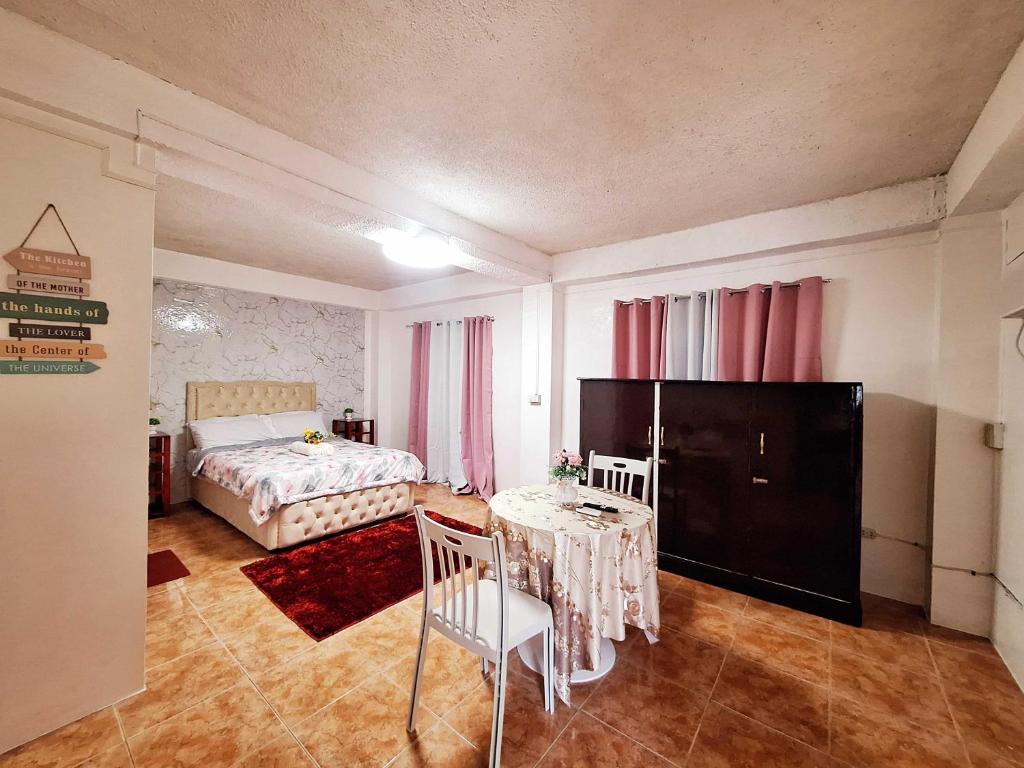 L4 Spacious Studio Apartment Near Airport, SM Lanang, SPMC & Ferry Wharf في مدينة دافاو: غرفة نوم بها سرير وطاولة وكراسي