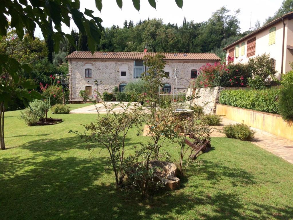 a garden in front of a stone house at Il Prunaio in Corsanico-Bargecchia