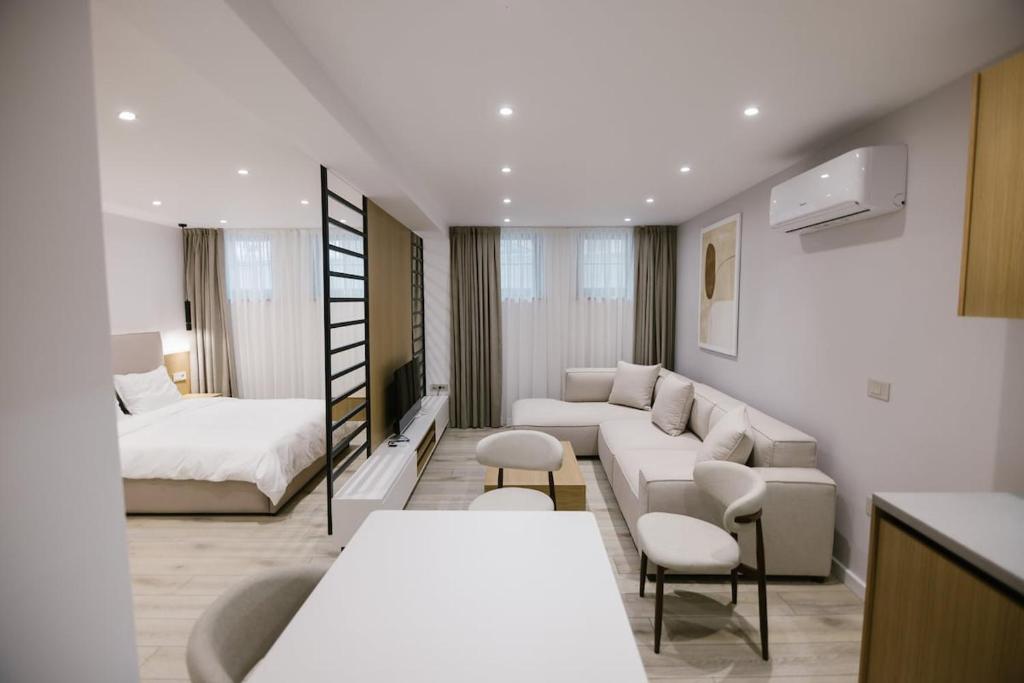ein Wohnzimmer mit einer Couch und einem Bett in der Unterkunft Vila Alko cozy studio apartment -1B in Korçë