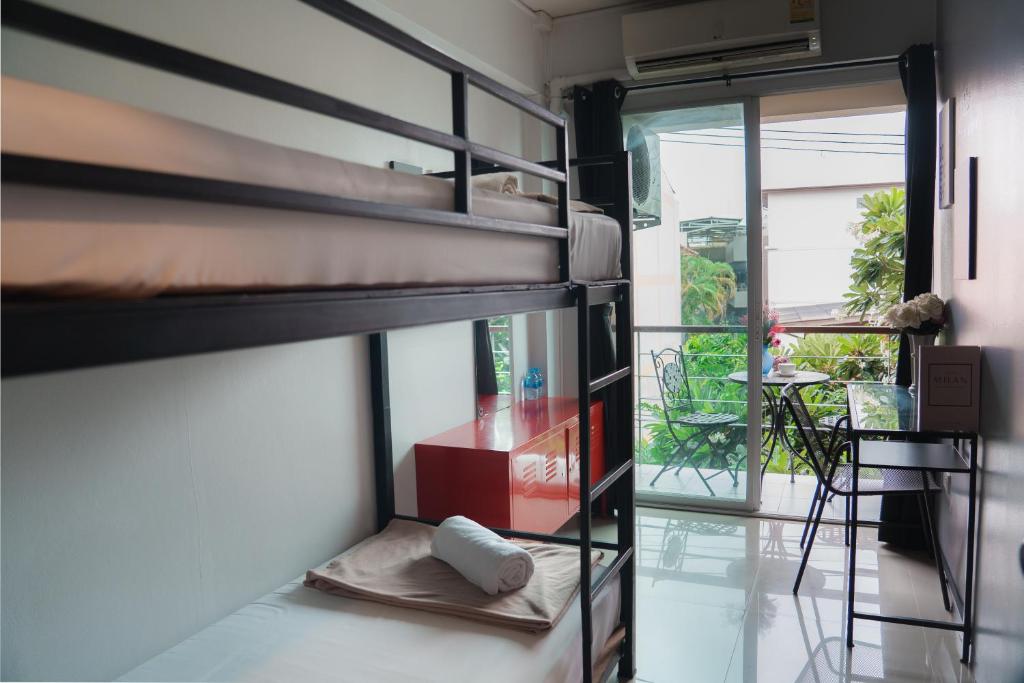 una habitación con dos literas y una mesa en Nature Home Hostel & Cafe, en Chiang Mai