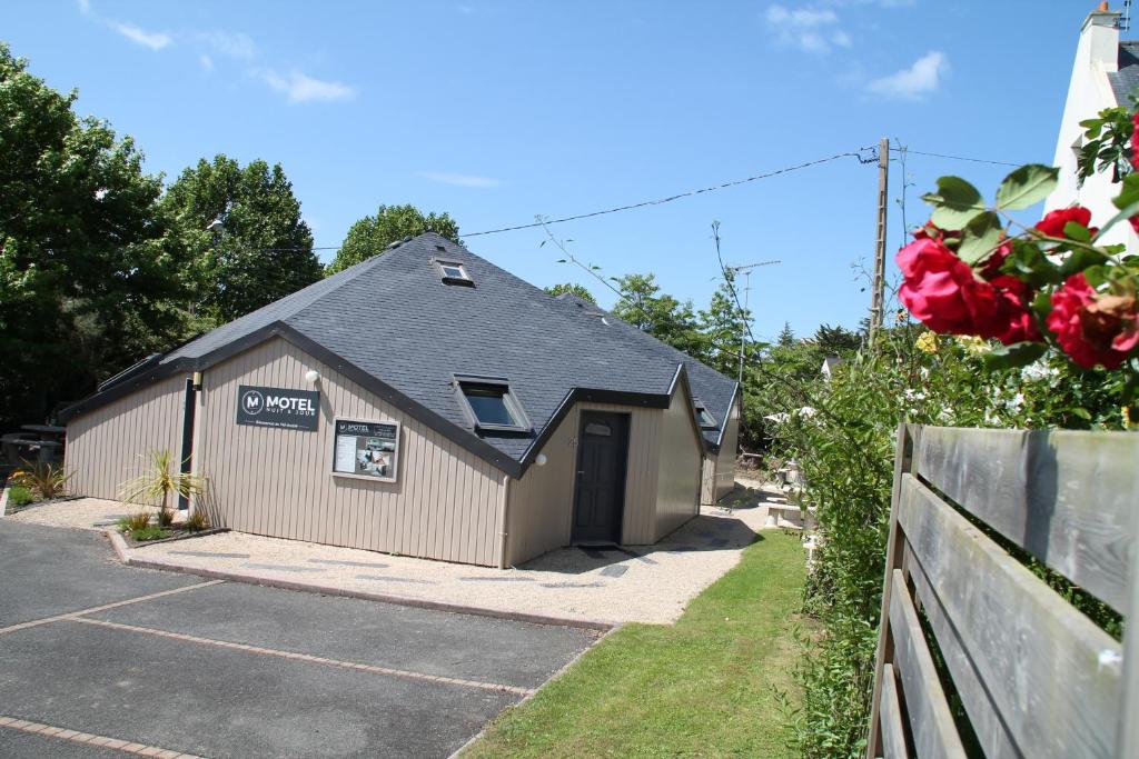 a building with a parking lot with a garage at Motel du Val André in Pléneuf-Val-André