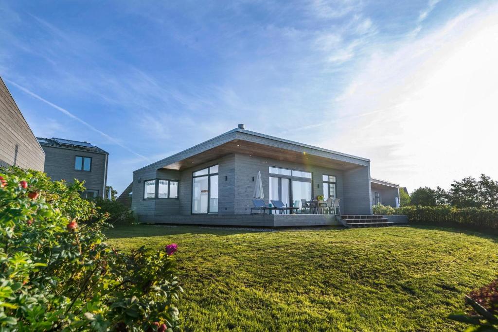 una pequeña casa en un césped frente a una casa en Auszeit, en Gelting
