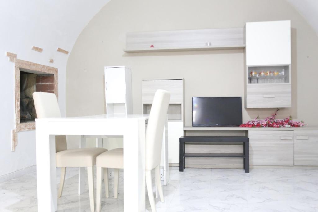 een witte eetkamer met een witte tafel en stoelen bij Corte Cosi&Mia Centro storico in Gallipoli