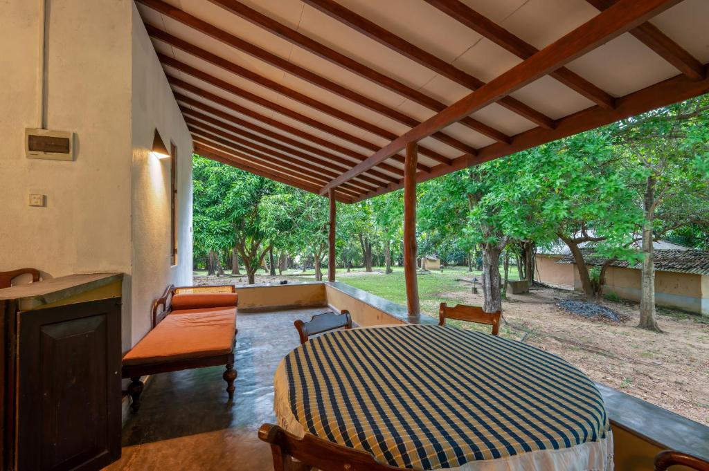 a porch with a bed and a table and chairs at WildEscape, Yala Blocks 3, 4 & 5 in Buttala
