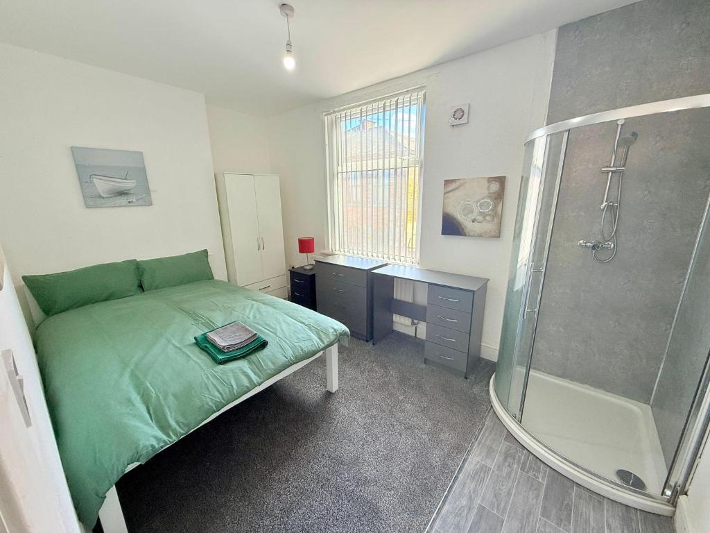 a bedroom with a green bed and a shower at BIG double room Attached Shower near to city center in Nottingham