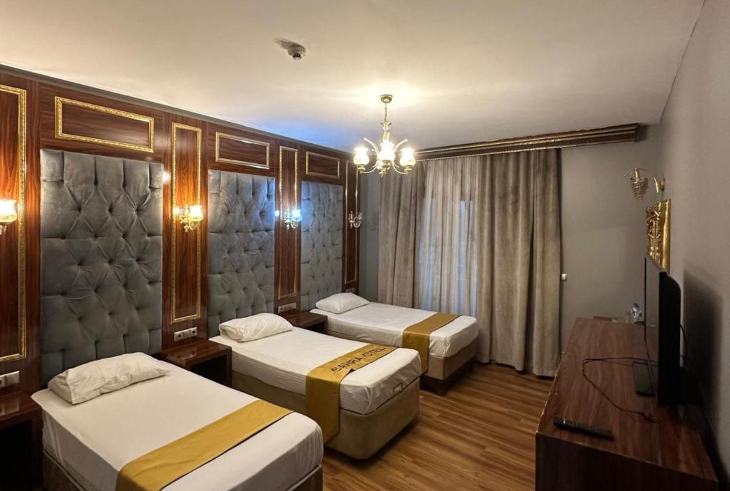 Una habitación de hotel con dos camas y un televisor. en Sahra Airport Hotel, en Estambul