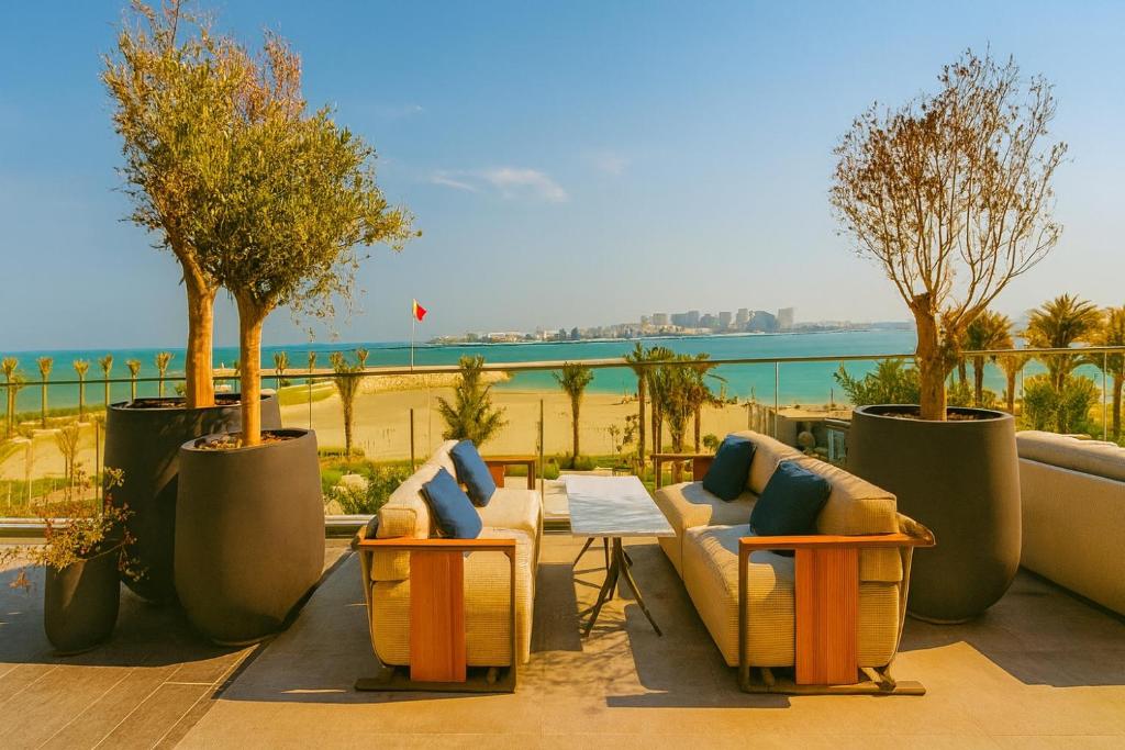 a patio with couches and a table with a view of the beach at Address Residence Marassi Vista-studio in Amwaj Island