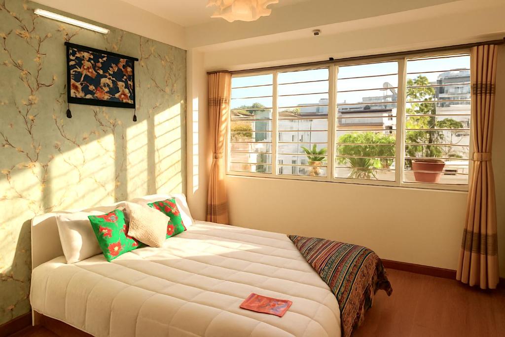 a bedroom with a bed in front of a window at Flower Homestay-Grand opening-VIP Homestay Local-Indochic-4Bedrooms in Hanoi