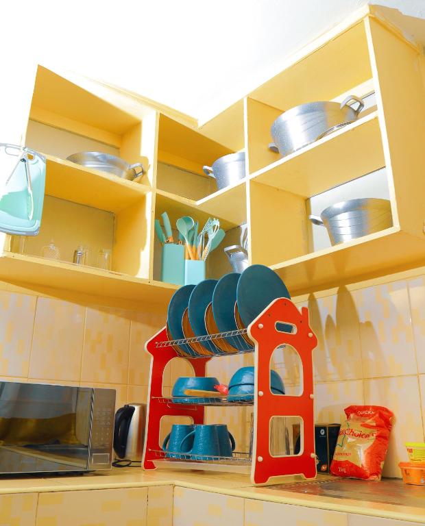 a kitchen counter with a microwave and some dishes at Shizzle cozy homes in Kisii