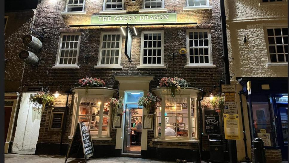 a brick building with a green privacy sign in front of it at The Green Dragon at Bedale in Bedale