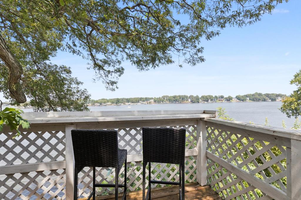 two chairs sitting on a porch overlooking the water at Dave's Last Resort Lakeside-Cozy Cabin 6 Hotel Room in Monticello