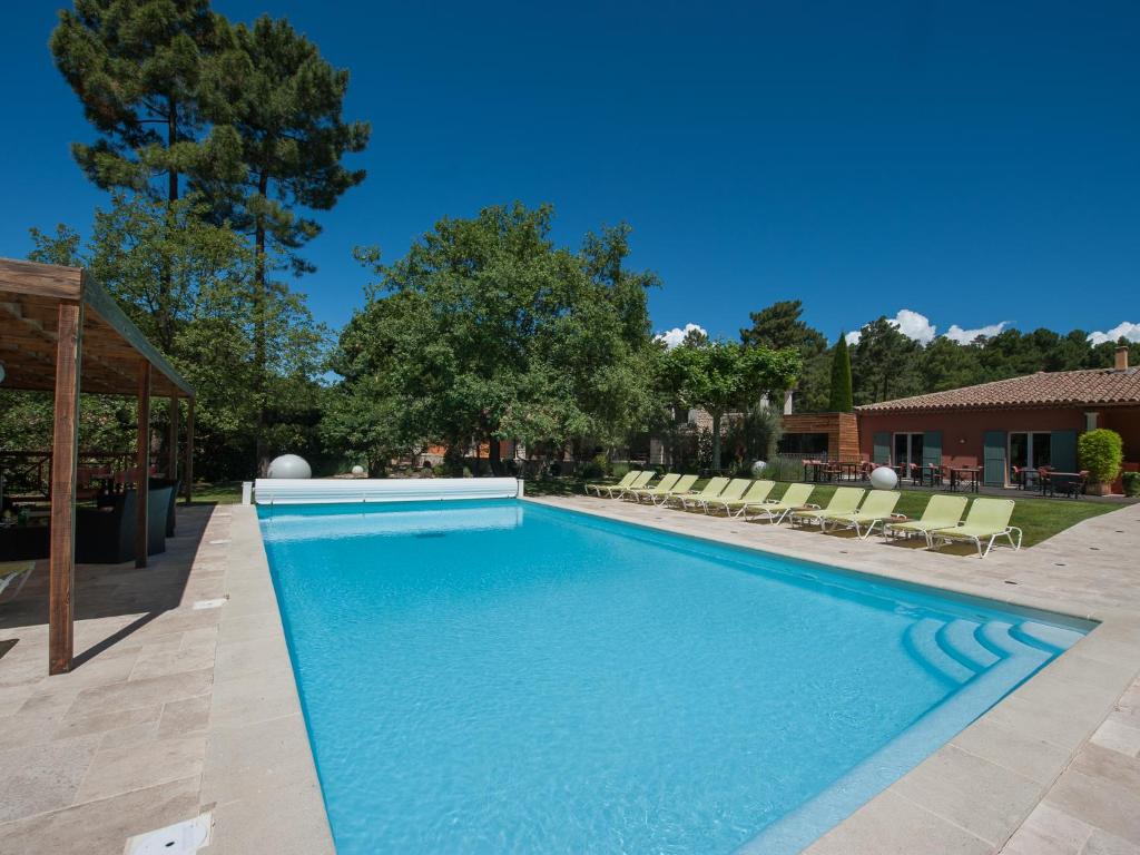 a pool in a backyard with a lawn chair at Les Sables d'Ocre in Roussillon