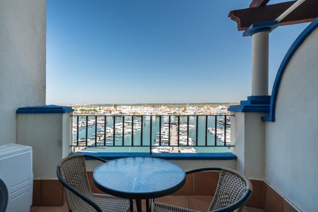 a balcony with a table and chairs and the ocean at Marina IV by Ĥ - Marina Isla Canela PMHIV25P25 in Isla del Moral