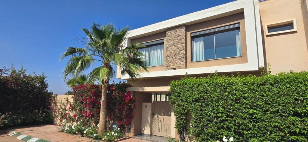 a house with a palm tree in front of it at Villa Saadia in Douar Bellouk