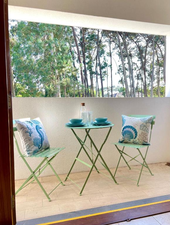 two chairs and a table in front of a window at Varandas do Pinhal in Fão
