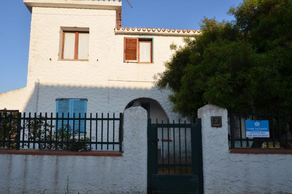 a white building with a gate in front of it at Fpo-Rose02p1 in Porto Ottiolu