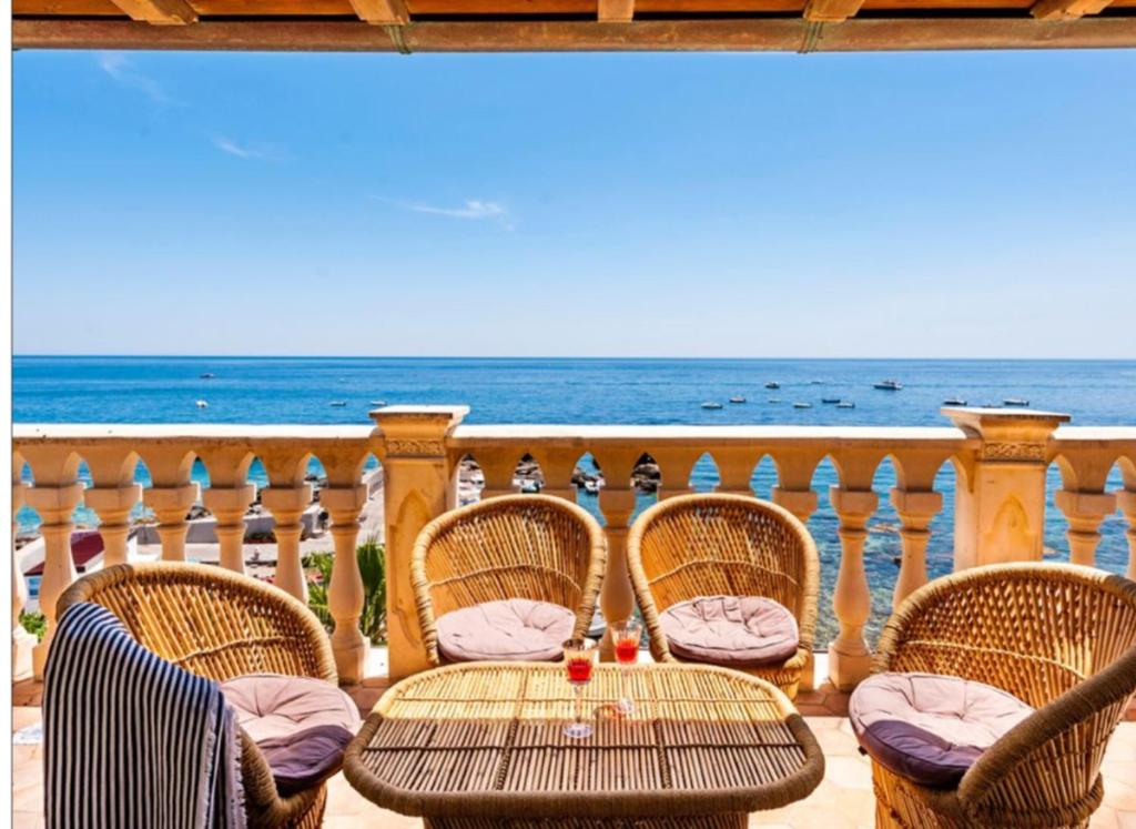 a table and chairs on a balcony with the ocean at VitaLenta in Naxos in Giardini Naxos