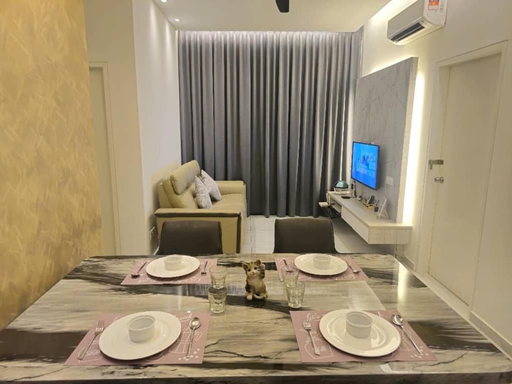 ein Wohnzimmer mit einem Esstisch mit Tellern und Gläsern in der Unterkunft Equine Residence - Taman Equine Seri Kembangan in Seri Kembangan