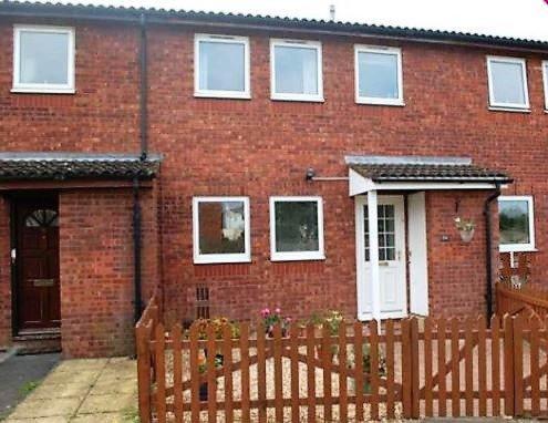 a brick house with a wooden fence in front of it at Shared Double Rooms in Buckinghamshire