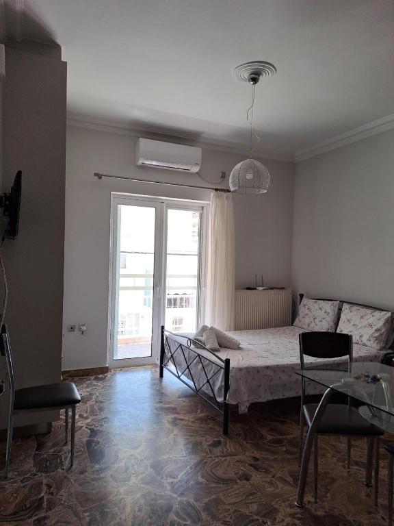 a bedroom with a bed and a large window at Sofia's apartment in Karistos