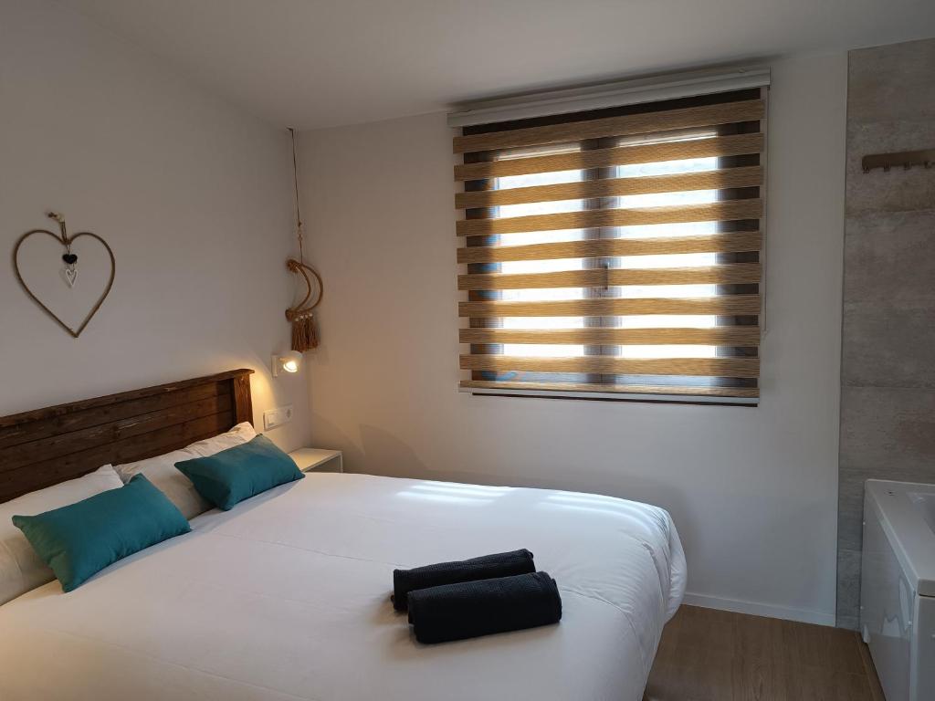 a bedroom with a bed with a black bag on it at Casas Natura Suites Graus in Graus