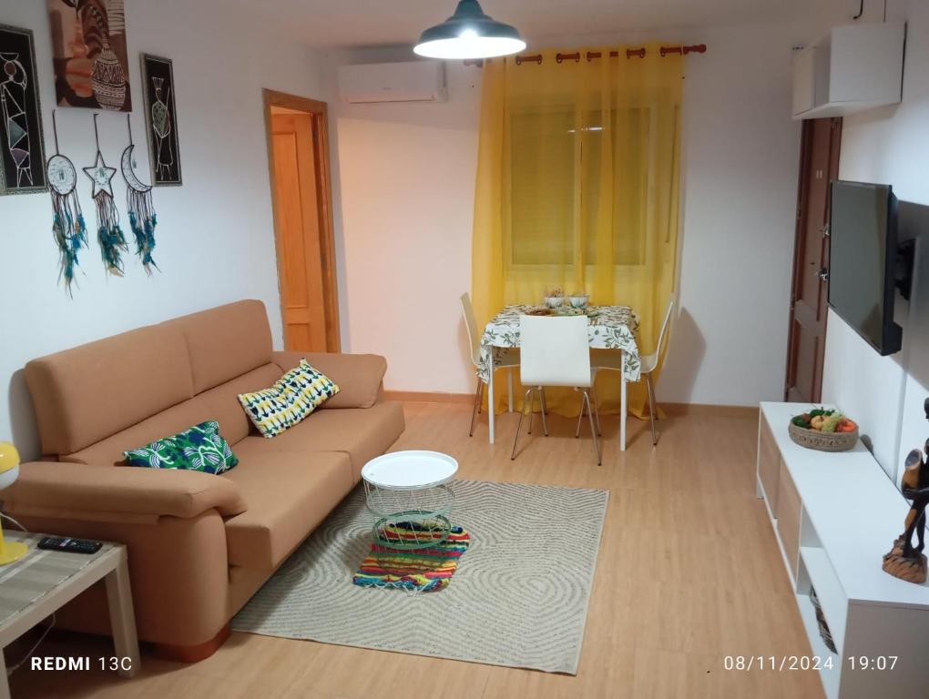 una sala de estar con un sofá y una mesa en SYL guest house centro ciudad, en Jaén