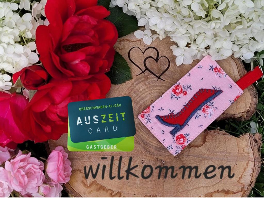 a book next to flowers and a pair of red high heels at Ferienwohnung Stiefel mit Garage & AusZeit Card in Wangen im Allgäu