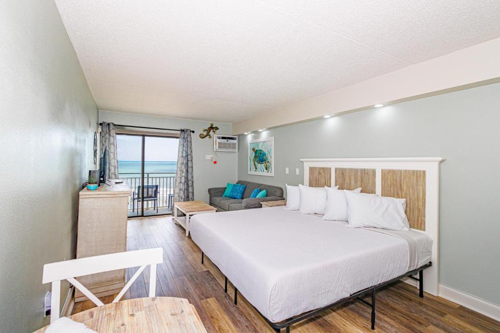 a bedroom with a bed and a living room at Ocean Front Condo Sea Mist 20509 in Myrtle Beach