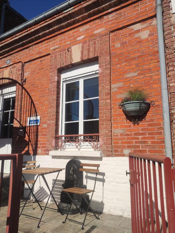 a brick building with two tables and a window at Maison duplex centre plage port cabine in Le Crotoy