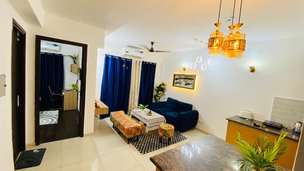 a living room with a blue couch and a blue chair at Zoom Stay Sector 168 Noida 1bhk in Noida